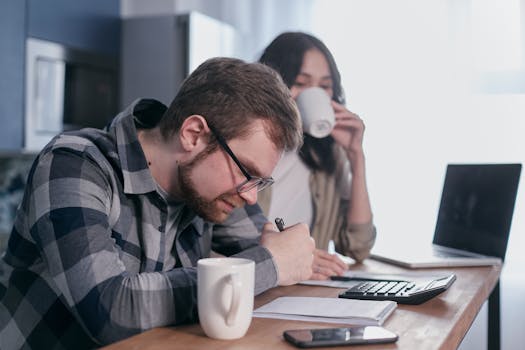 Man in Gray and Black Plaid Dress Shirt Wearing Black Framed Eyeglasses Holding White Ceramic Mug