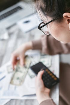 Woman in Eyeglasses Holding Money and Cellphone